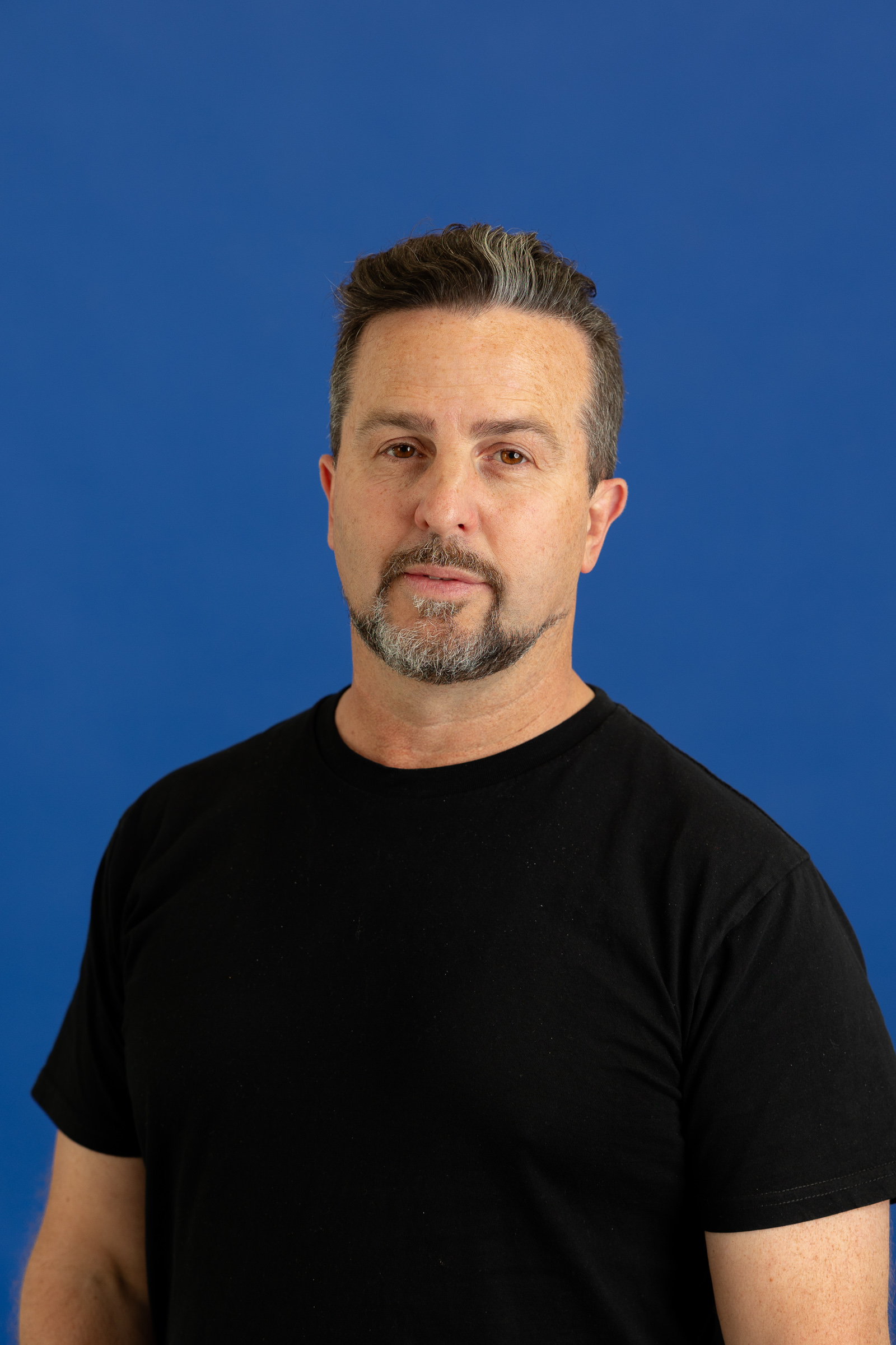 Andrew Mcpherson Headshot on blue background