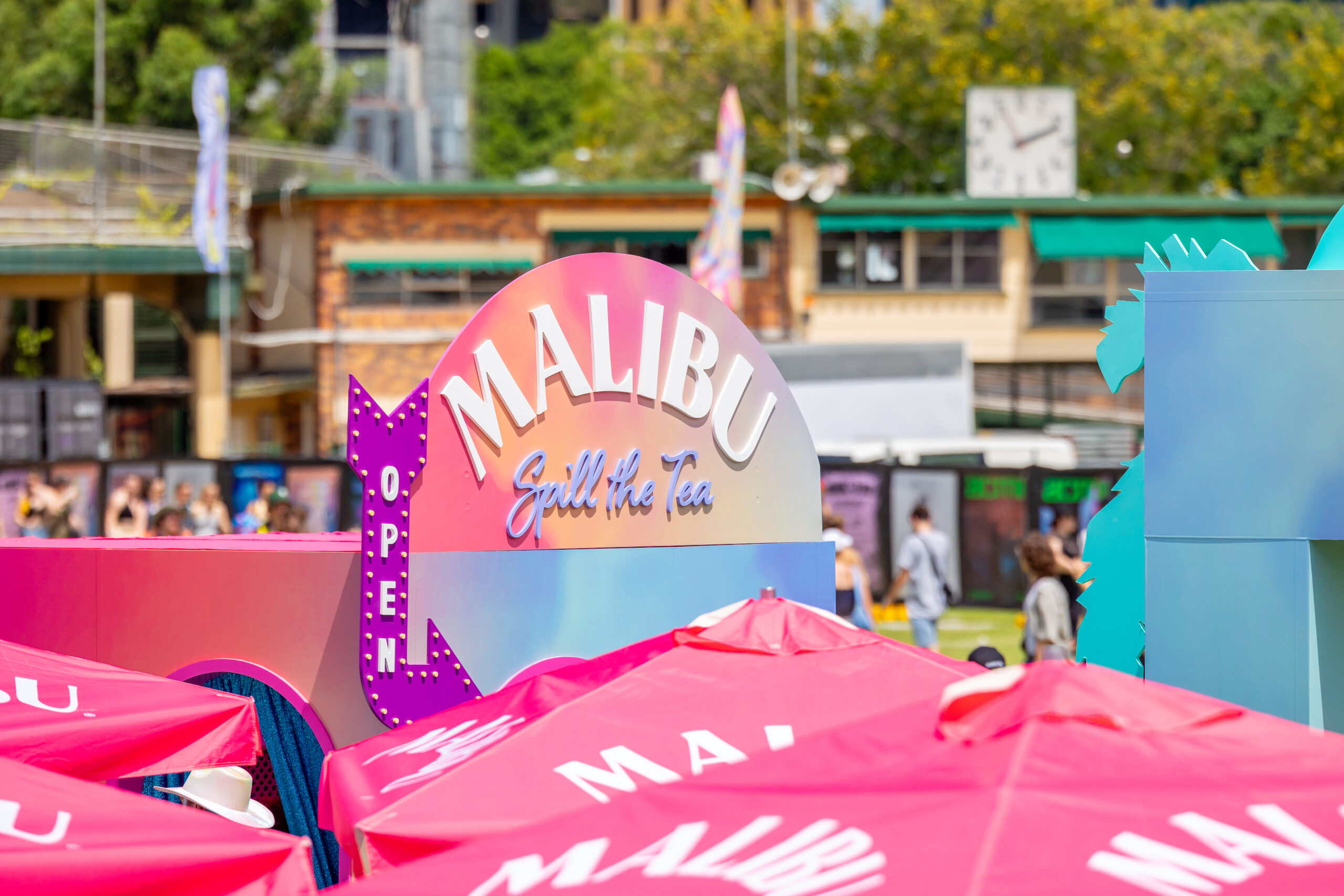 Multicoloured Signage to the 'Spill the Tea' Enclosed Area and a Purple Arrow with White 'Open' Lettering.