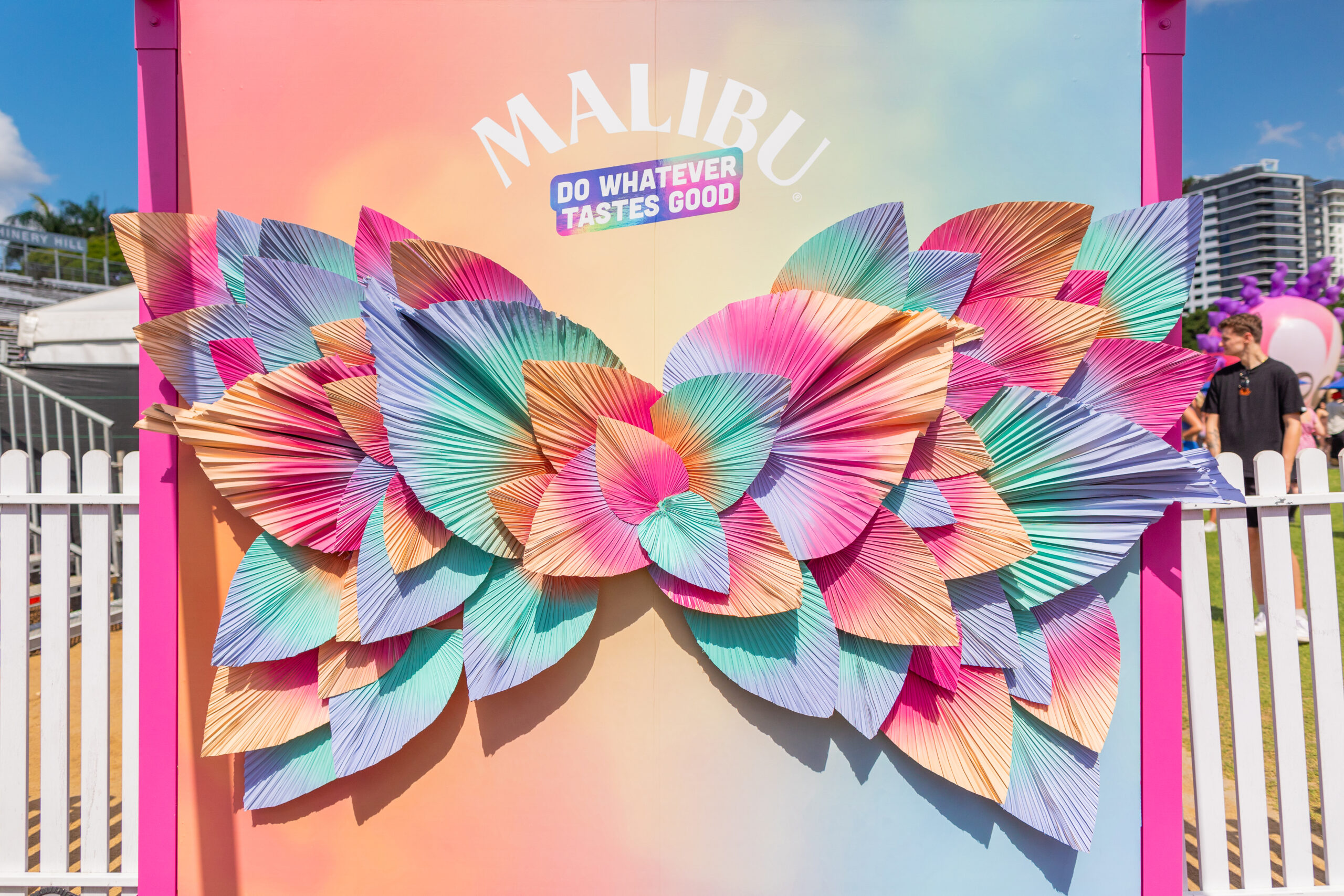 Multicoloured Spray Painted Leaf Photo Moment Backdrop with Malibu Signage.